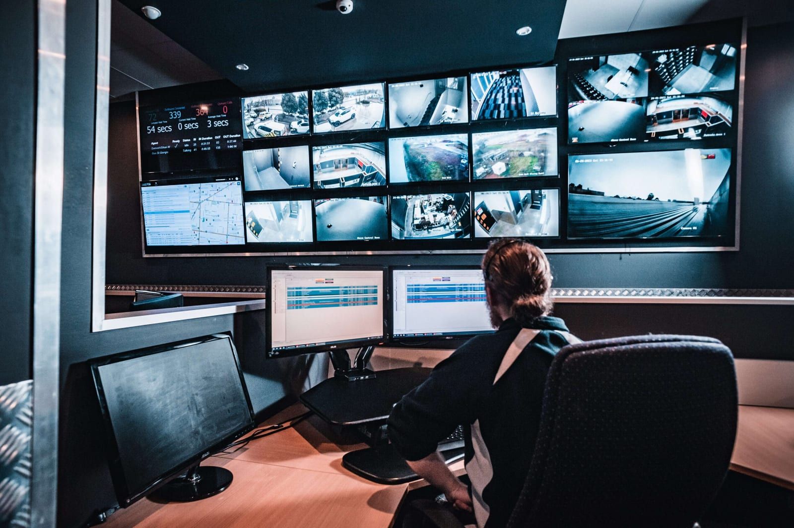 An operator at the alarm monitoring control room in Vermont, with the camera wall behind